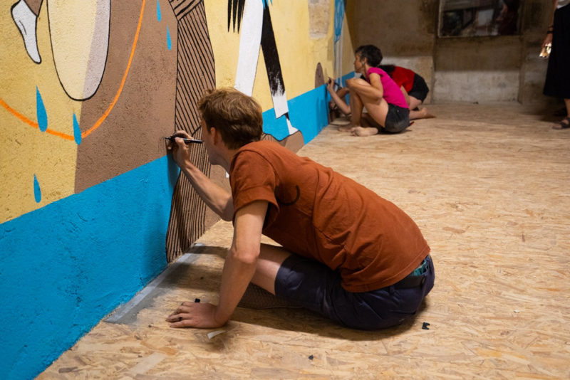 Les illustrateurs Matthieu Méron, Lucie Albon et Aurore Petit travaillant à la fresque "fil de vie" sur les murs de l'espace Marceline Lartigue à la Bergerie de Soffin.