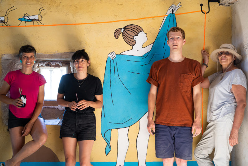 Les illustrateurs Lucie Albon, Aurore Petit et Matthieu Méron posent avec Patricia Lucas devant la fresque "fil de vie" à la Bergerie de Soffin.
