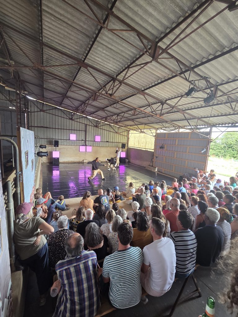spectateurs d'un spectacle de break dance sous un hangar agricole