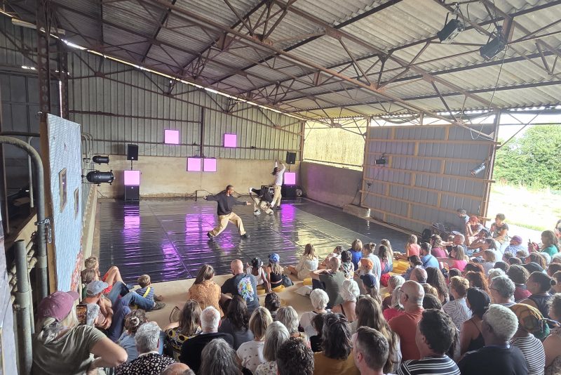 spectateurs d'un spectacle de break dance sous un hangar agricole